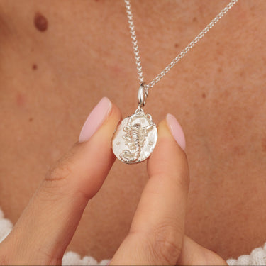 Silver Scorpio star sign charm pendant in hands