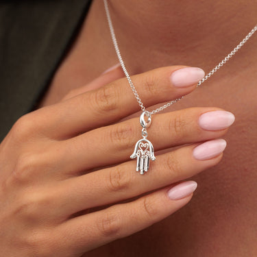 Woman Holding Silver Fatima Hand Charm Necklace | Hamsa Pendant Necklace
