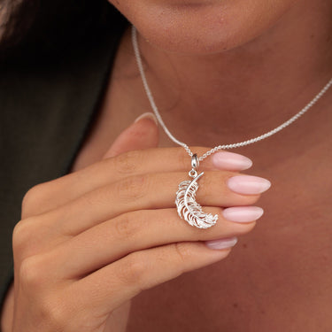 Woman Holding Large Silver Feather Charm Necklace | Feather Pendant