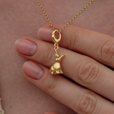 Woman Holding Gold Bunny Charm Necklace | Animal Inspired Pendant Necklace 