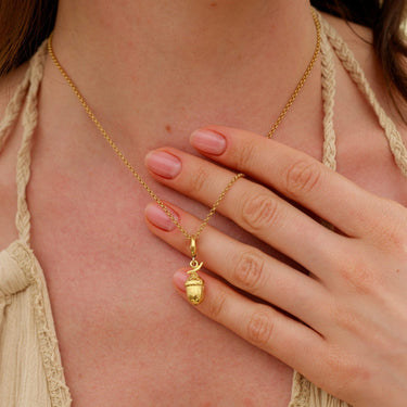 Woman Holding Gold Acorn Charm Necklace | Nature Pendant