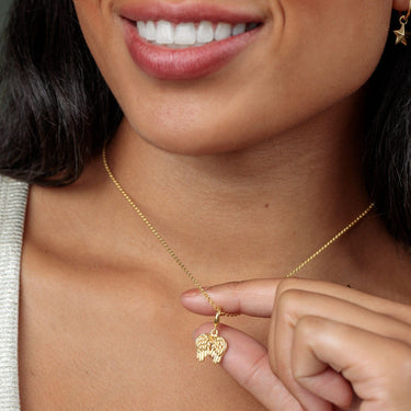 Woman Holding a Gold Angel Wings Charm Necklace | Angel Wings Pendant