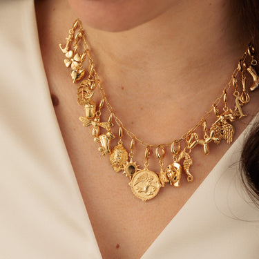 Gold Charm Necklace with Many charms on boxlink chain necklace on model neck neutral background