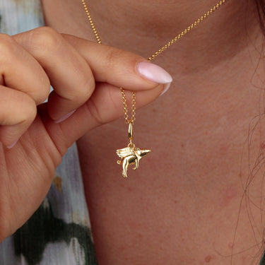 Woman Holding Gold Flying Pig Charm Necklace | Animal Pendant Necklace