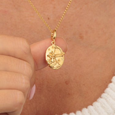 Gold Sagittarius zodiac charm pendant with 3D motif in hands