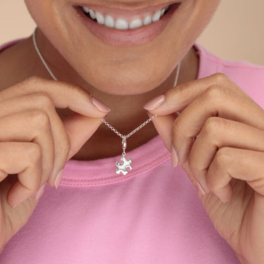 Woman Holding Silver Jigsaw Charm Necklace | Puzzle Piece Pendant Necklace
