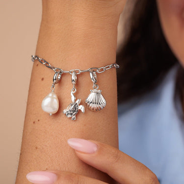 Silver clam shell charm on charm bracelet