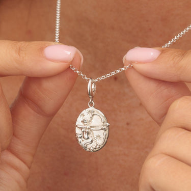 Silver Sagittarius zodiac charm pendant in hands
