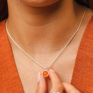 Woman Holding Silver Orange Agate Healing Stone Charm Necklace - Healing Crystal Pendant